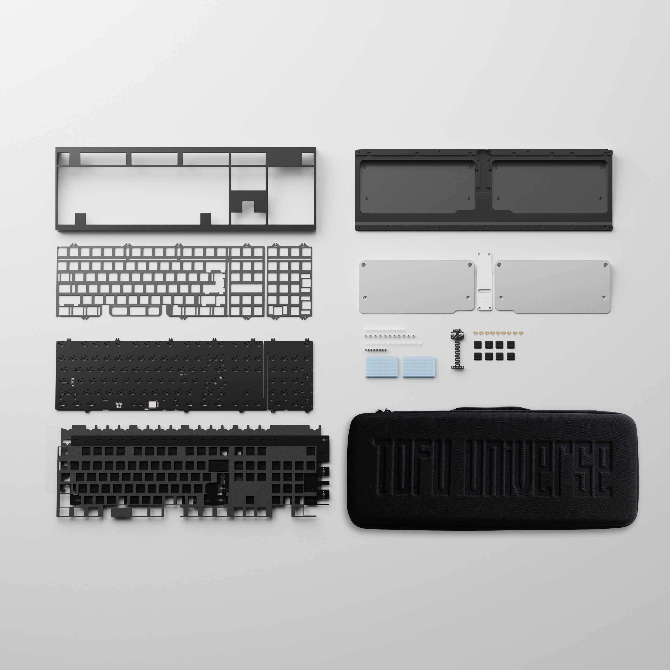 Exploded mechanical keyboard kit showing the case, plate, PCB, internal weights, foam, hardware and carrying case